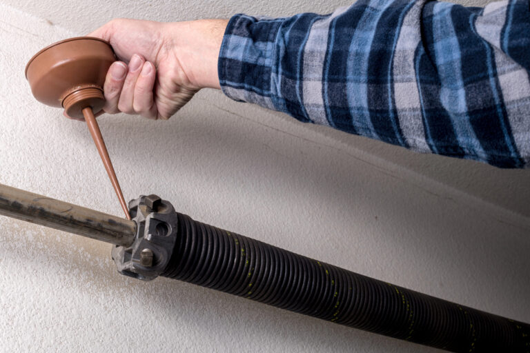 Garage door main spring being oiled