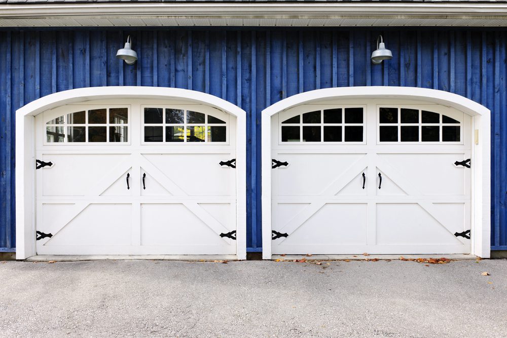 blue house with white garage doors with arches